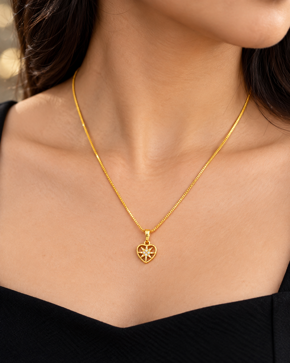 Small heart-shaped starburst pendant in a gold plated chain