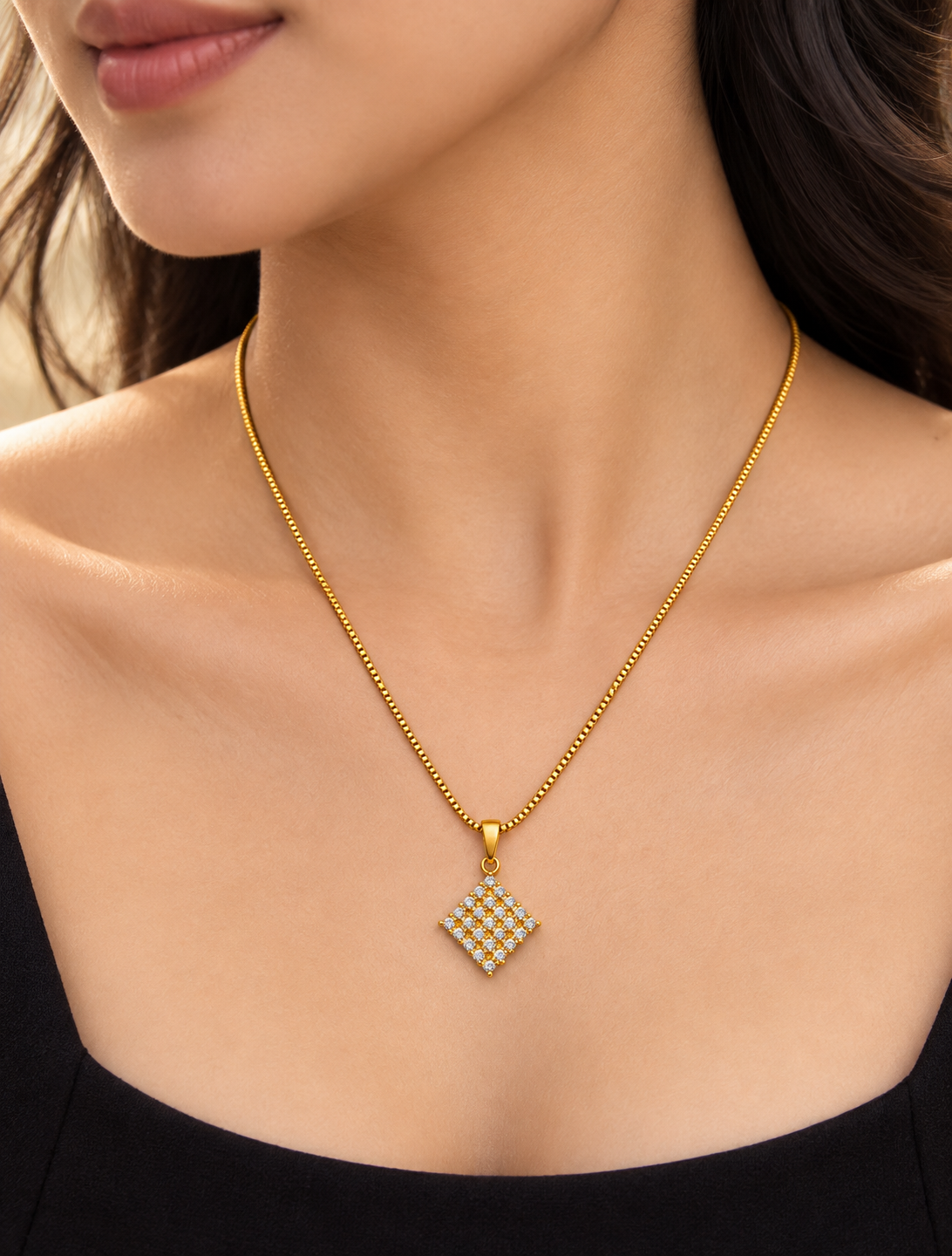 Square diamond-shaped pendant set with sparkling stones in a gold plated chain