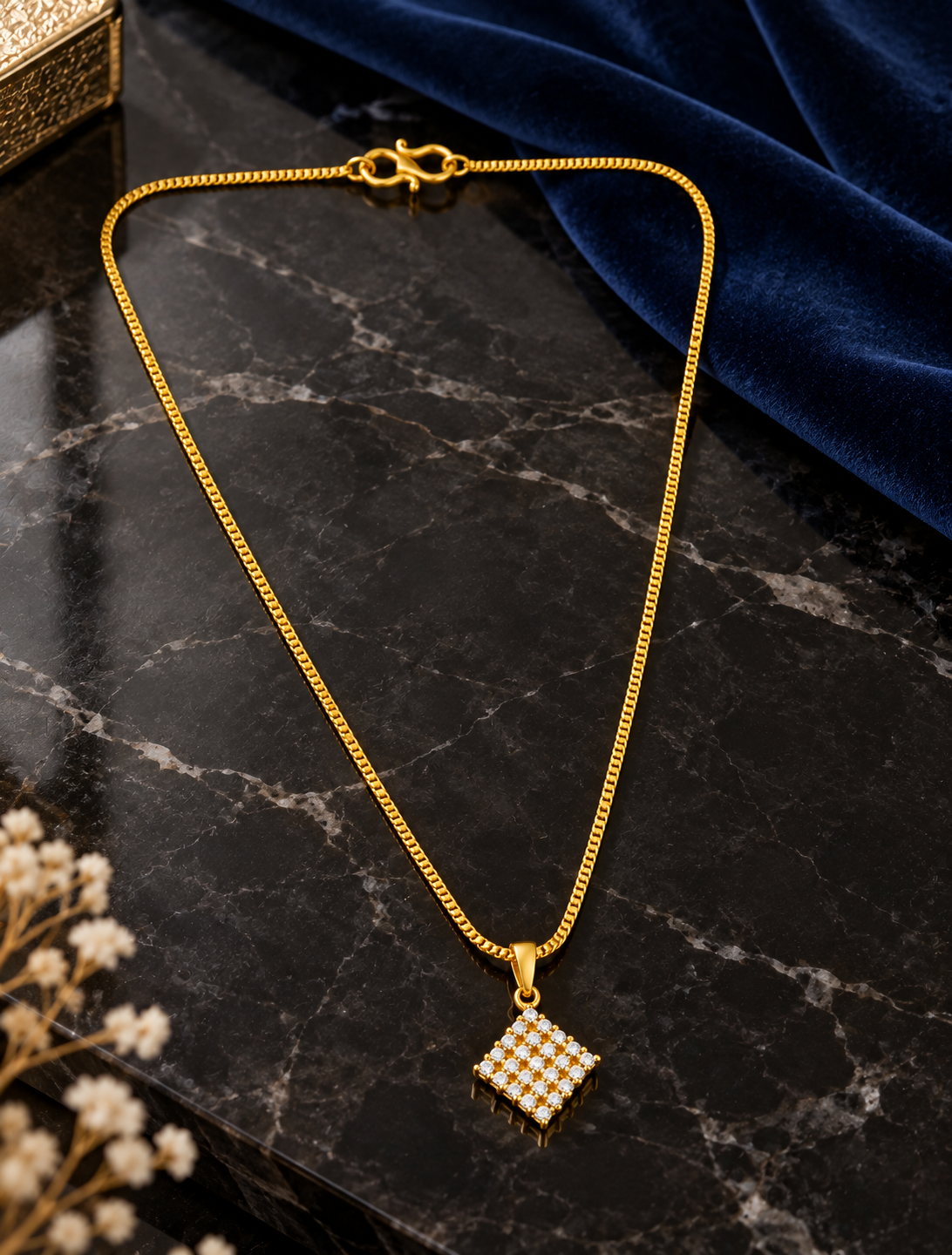 Square diamond-shaped pendant set with sparkling stones in a gold plated chain