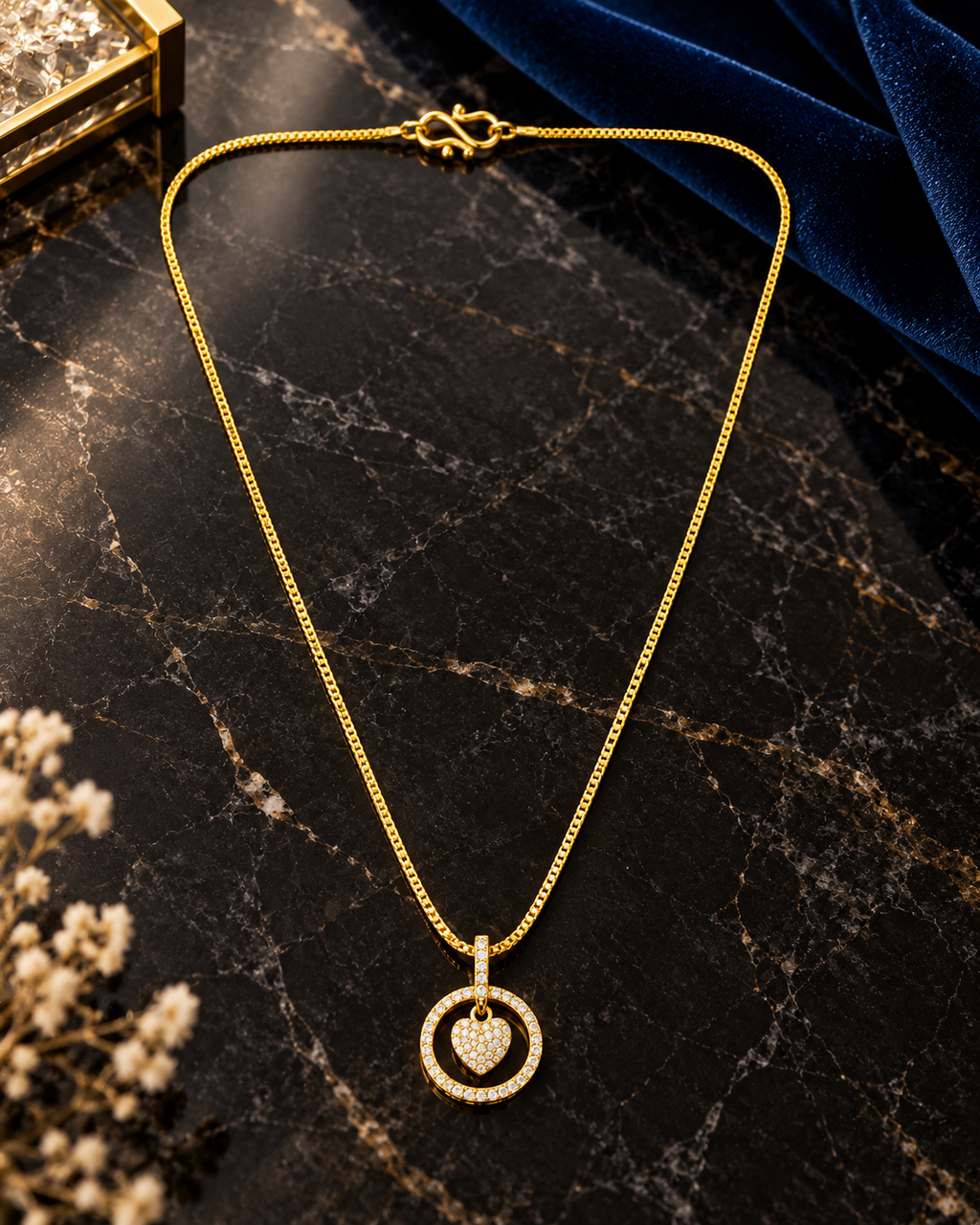 A gold chain necklace with a heart-shaped pendant set in a circular ring design.